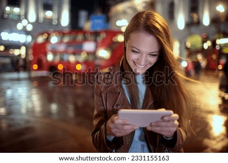 Young woman using a smart phone while walking in the city london