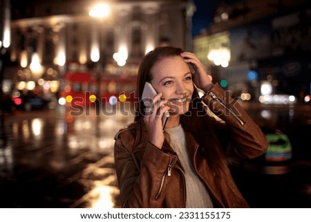 Young woman having a phone call while walking in the city london