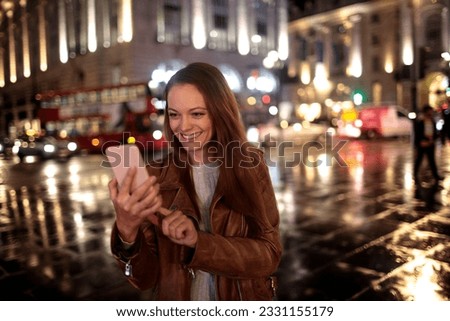 Young woman using a smart phone while walking in the city london