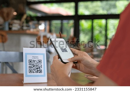 Woman use smartphone to scan QR code for order menu in cafe restaurant with a digital delivery. Choose menu and order accumulate discount. E wallet, technology, pay online, credit card, bank app. Royalty-Free Stock Photo #2331155847