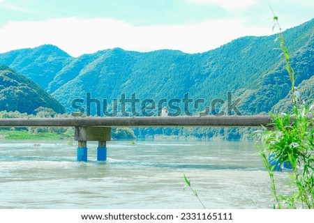 A woman taking a picture at a subsidence bridge on the Shimanto River