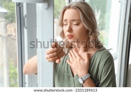 Young woman having panic attack near window Royalty-Free Stock Photo #2331189613