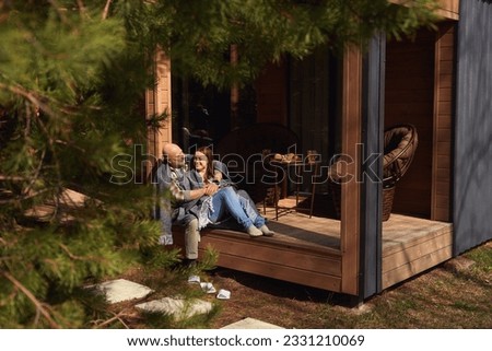 Couple in love resting on cottage veranda Royalty-Free Stock Photo #2331210069