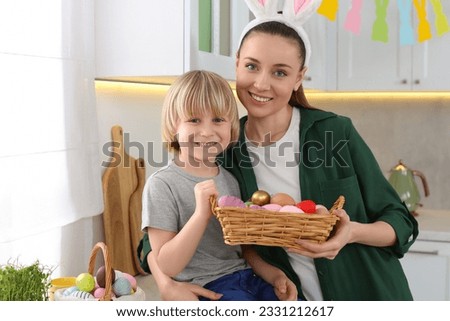 Mother and her son with Easter eggs in kitchen