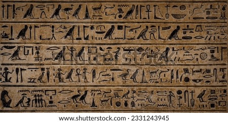 Old Egyptian hieroglyphs on an ancient background. Wide historical background. Ancient Egyptian hieroglyphs as a symbol of the history of the Earth.  Royalty-Free Stock Photo #2331243945