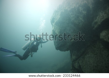 Scuba diver toward a rock in Lake Barracuda, Coron Island, Palawan. The rock looks like sphinx statue in a specific angle.