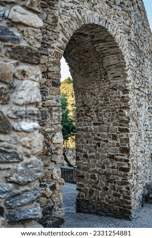 Entrance arch in medieval village wall at sunset.