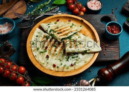 Traditional azerbaijan cuisine flat bread with herbs and meat. Kutaby qutab kutab. Free space for text. On a dark background. Royalty-Free Stock Photo #2331264085