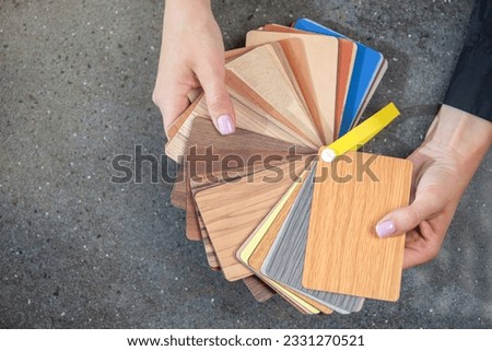 laminate samples. The choice of laminated surface for chipboard. Samples of wood imitation laminate in hands, close-up. Royalty-Free Stock Photo #2331270521
