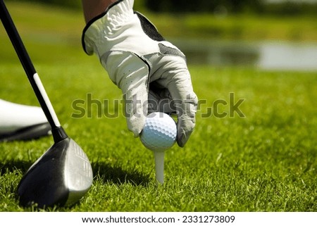 Golf club- golfer arranging the ball on the tee