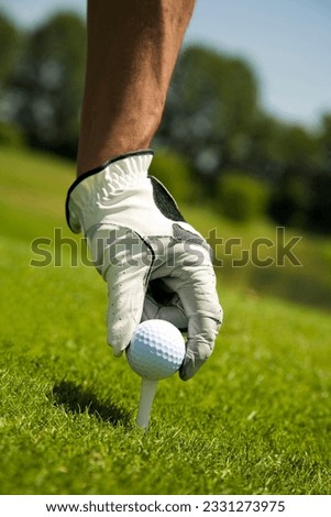Golf club- golfer arranging the ball on the tee