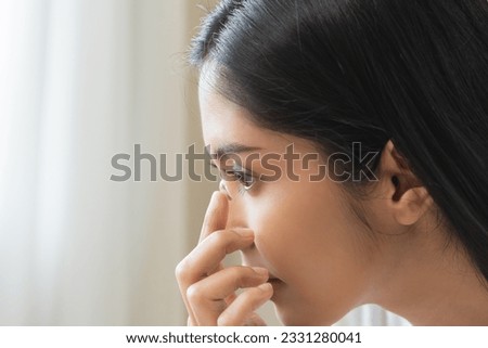 Ophthalmology care, eye sight or vision. Closeup asian young woman, female hand holding and putting, wearing soft contact lens on face with finger, look into eye on background. Medicine and health. Royalty-Free Stock Photo #2331280041