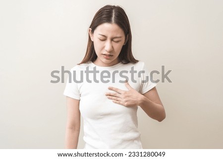 Acid reflux disease, suffer asian young woman have symptom gastroesophageal, esophageal, stomach ache and heartburn pain hand on chest from digestion problem after eat food, Healthcare medical concept Royalty-Free Stock Photo #2331280049