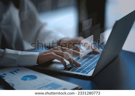 Close-up. Woman hand using computer laptop and sending online message with email icon. Concept of sending e-mails with laptop computer.