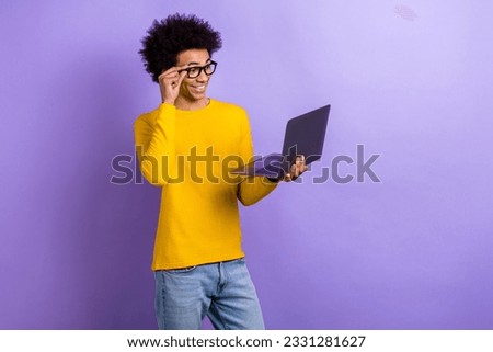 Photo of positive smart handsome man hand touch eyeglasses hold use wireless netbook isolated on violet color background