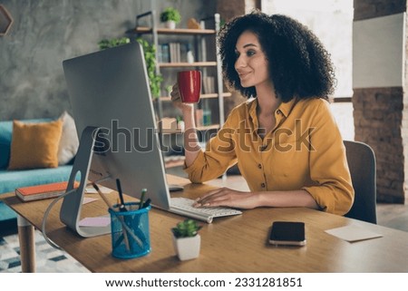 Photo of cute cheerful lady leader dressed shirt smiling communicating modern gadget drinking tea indoors workstation workshop