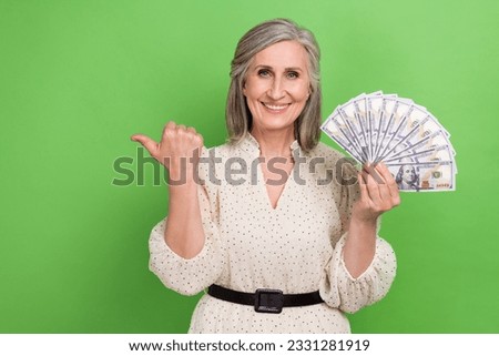 Photo of pretty cute lady wear beige dress holding cash fan thumb empty space isolated green color background