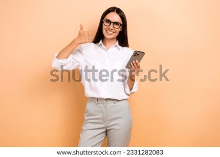 Photo of happy confident lady wear white shirt spectacles writing modern gadget thumb up isolated beige color background