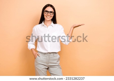 Photo of smiling cheerful lady wear white shirt spectacles holding arm empty space isolated beige color background
