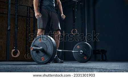 Sportsman performing weight lifting exercise at gym, croped shot, low angle view focus on barbell. Royalty-Free Stock Photo #2331301903