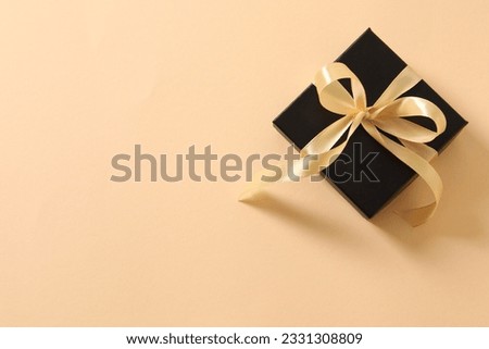 beautiful gift with a yellow ribbon on a colored background