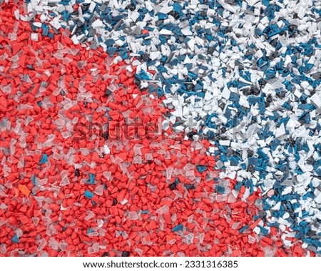 Recycled crushed plastic. Recycling and reuse of plastic. The problem of environmental pollution. Ecology and innovations. Various types of plastic in red and blue. Royalty-Free Stock Photo #2331316385