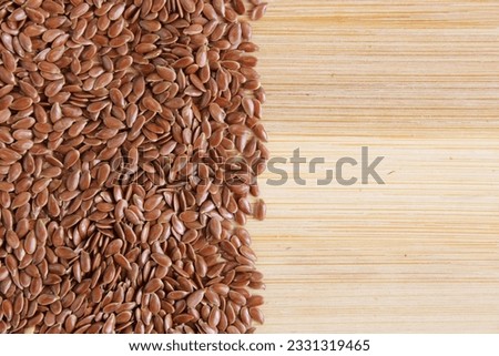 This is a photo shot of flaxseeds on wood board. 