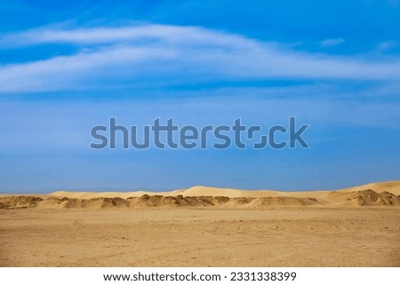 View of expenses of Sahara desert sunny day, sand dunes and stones. Landscape photography of desert hills with sand, vegetation and blue sky, Sahara, Tozeur city, Tunisia, Africa. Copy ad text space