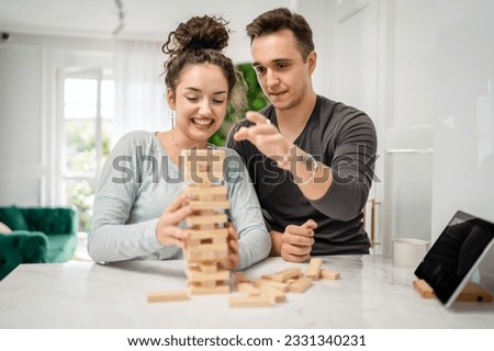 woman and man happy caucasian couple husband and wife or friends playing jenga table game at home having fun happy smile leisure time spending time together family time copy space real people Royalty-Free Stock Photo #2331340231