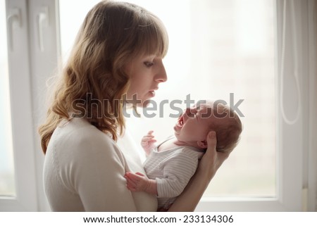young mother with crying baby Royalty-Free Stock Photo #233134306