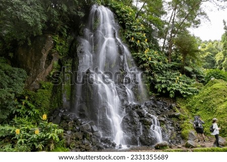 Waterfall at Ribeira dos Caldeirões in Nordeste with tourists, Sao Miguel island in the Azores. Royalty-Free Stock Photo #2331355689