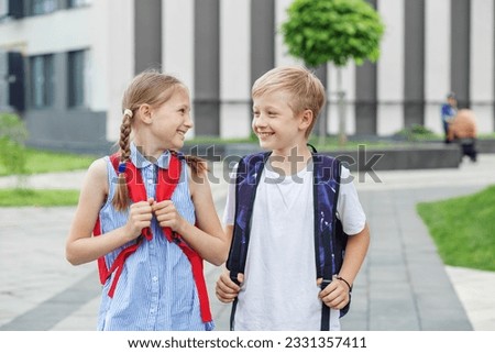 Concept of school, study, education, friendship, childhood. Classmates backpack behind back. Children go to school for study. Beginning of school lessons. Royalty-Free Stock Photo #2331357411