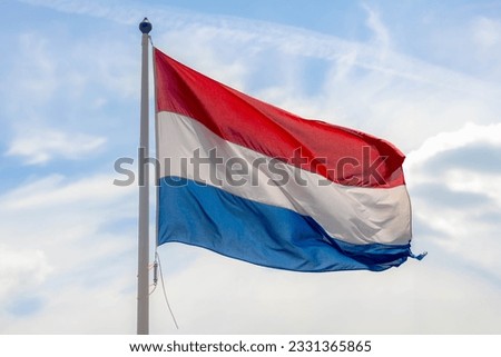 National flag of the Netherlands with horizontal tricolour of red, white and blue, Dutch flag waving on the air in a sunny day as background.