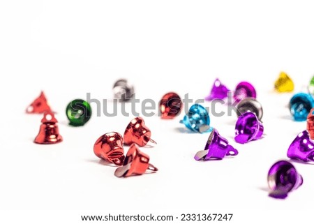 Close up of colorful miniature metal bells on white background with depth of field. Alert concept.