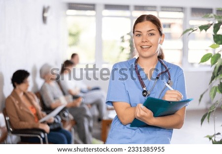 Portrait of friendly female doctor wearing uniform and stethoscope with folder