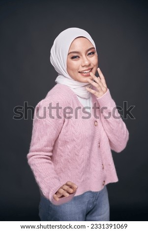 Portrait of hijab girl in sweatshirt smiling. Pretty muslim girl. Beautiful Asian malay woman model posing on dark background studio.