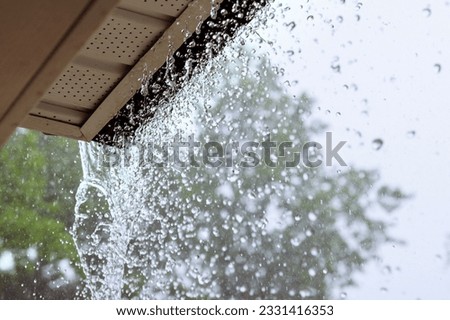 During downpour, water escapes from over gutters. Royalty-Free Stock Photo #2331416353