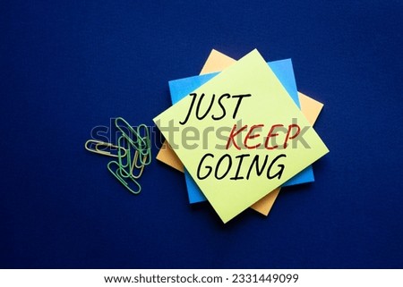 Just keep going symbol. Yellow steaky note with words Just keep going. Beautiful deep blue background. Business and Just keep going concept. Copy space.