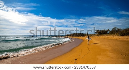 beautiful long hair girl in white shirt walking on a paradise beach in deepwater national park near agnes water, queensland, australia; relax on the tropical beach with red sand	 Royalty-Free Stock Photo #2331470559