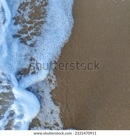 Waves on the beach. Sea water and fine sand.
