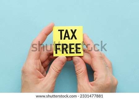 Yellow Sticker on a colored background in hands with the text Tax Free.