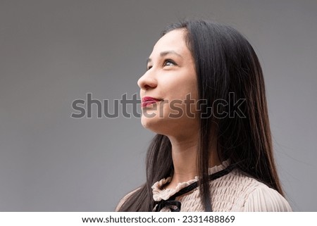 Close-up portrait of a Filipina woman confidently looking towards the future. Captured in profile, her gaze is directed upward and to the left, towards your COPYSPACE Royalty-Free Stock Photo #2331488869