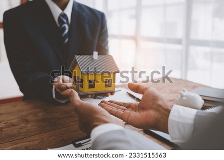 Real estate agents and insurance salesmen for home and land purchases are handing over homes to clients after agreeing and signing contracts in the office.