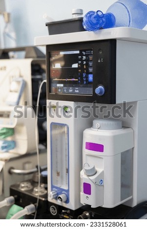 The gas anesthesia machine stands in a clean light surgery ready for operation. A ventilator ready for use in an empty operating room. Anesthesia equipment concept.