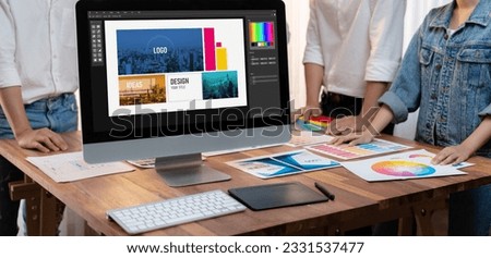 Graphic designer brainstorming logo and graphic art at busy artistic workshop, laptop display workspace. Experimenting color palette and pattern for creative design. Panorama shot. Scrutinize