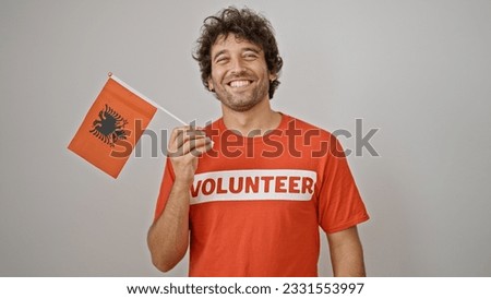 Young hispanic man activist holding albanian flag over isolated white background