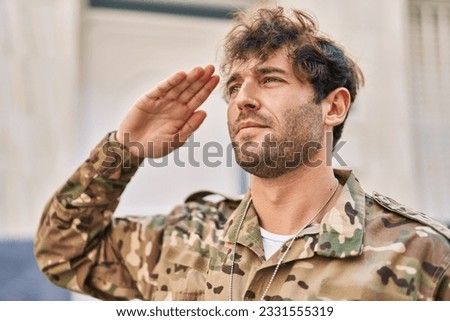 Young man army soldier doing militar salute at street