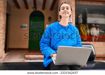 Young caucasian woman smiling confident using laptop at street