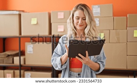 Young blonde woman ecommerce business worker using touchpad smiling at office