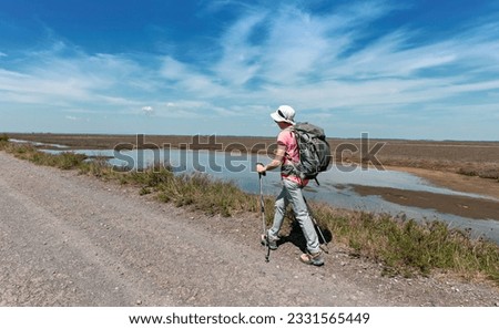 a woman walking on the dirt road